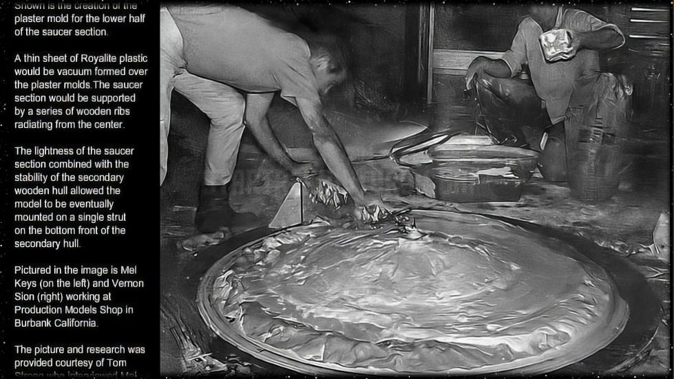 A group of men working on a large round object Description automatically generated